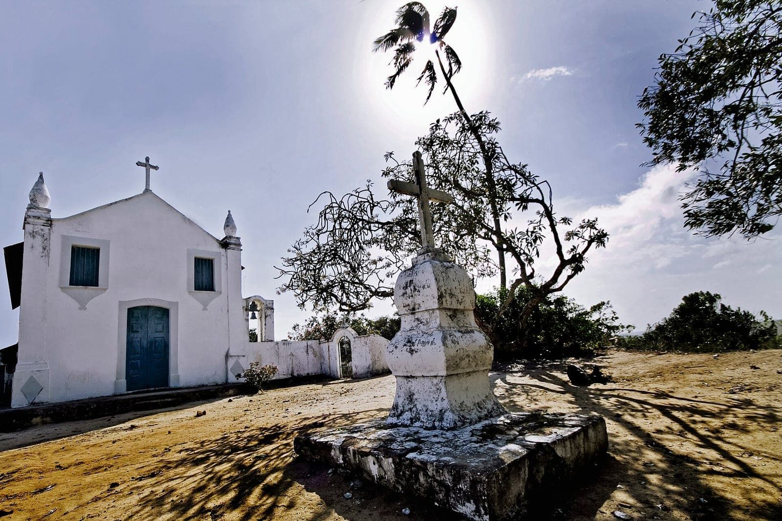 Igreja branca do Oiteiro, em Porto de Galinhas, com um cruzeiro em primeiro plano