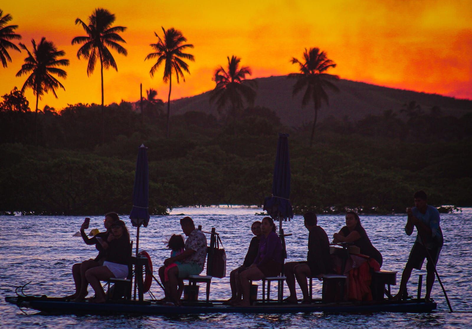 Silhueta de pessoas numa jangada ao pôr do sol em Maracaípe