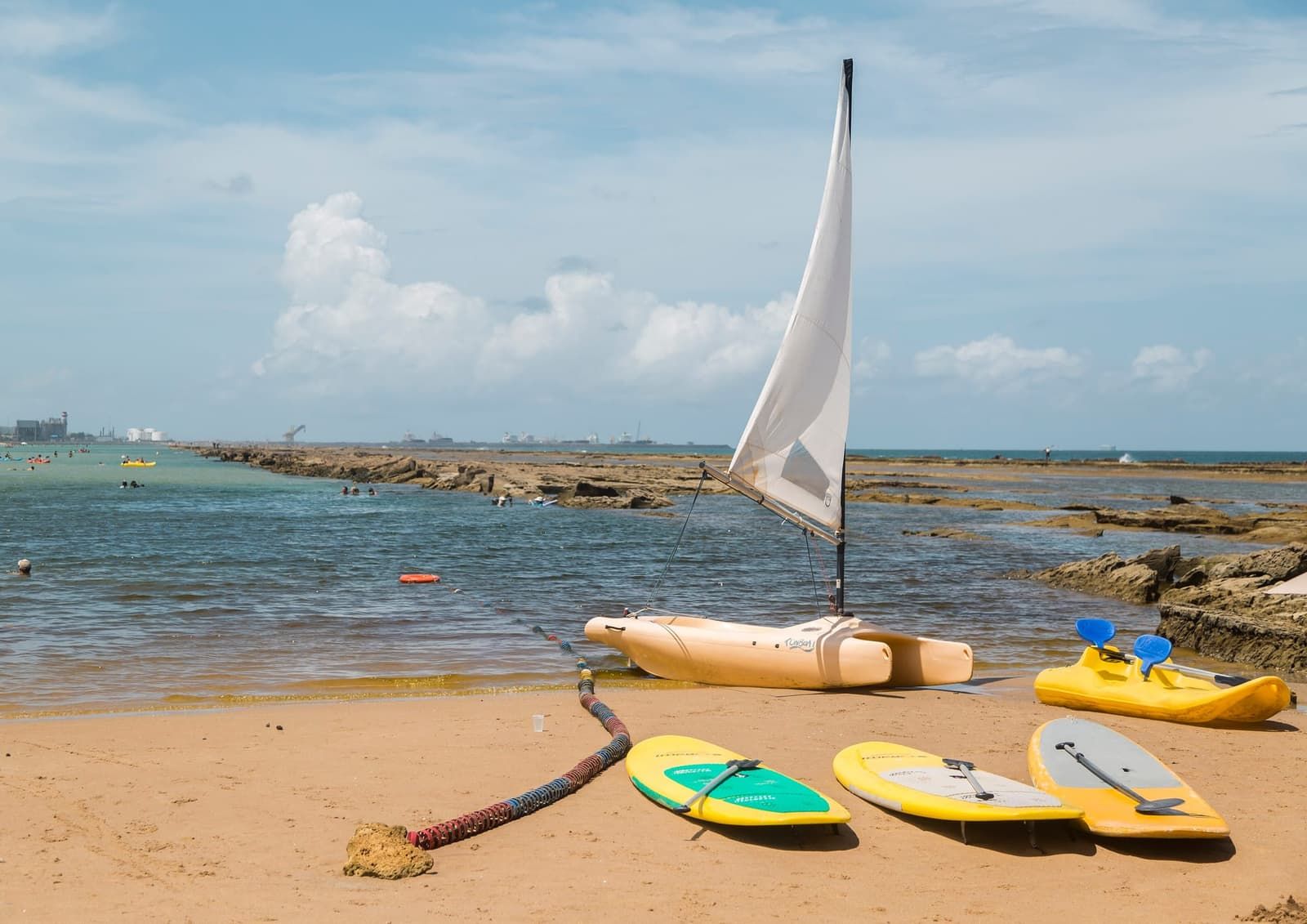 Praia de Muro Alto com barco a vela e caiaques na areia diante da piscina protegida pela barreira de recifes